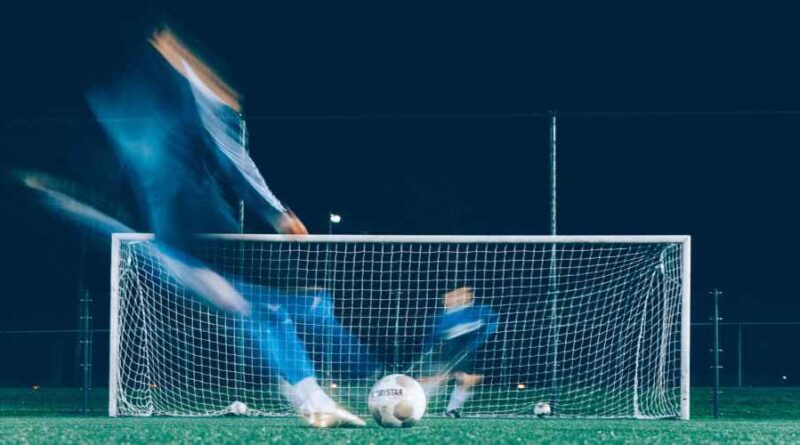 Een speler schiet op doel op deze bewogen foto, genomen tijdens een voetbal training. Foto unsplash